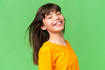 Young little brunette girl happy over isolated green background © luismolinero