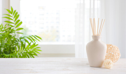 Wooden table and incense sticks vase on blurred window background - obrazy, fototapety, plakaty