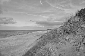 Beach crossing in Denmark by the sea taken in black and white. Dunes, sand water