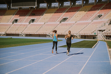 Two sportspeople jogging at the stadium