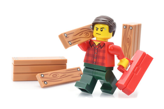 Editorial illustrative image to carpenter occupation plastic lego minifigure toy by working with wooden Bretts.