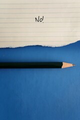 Torn lined note paper, pencil with text written NO!  pencil on blue background with copy space. Concept of remind oneself to stop being people pleaser and learn to say no or boundaries setting