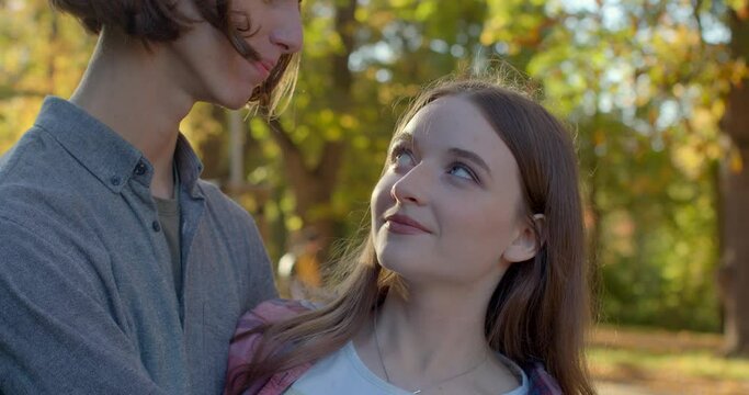 Close-up young couple portrait. Girl initiate eye contact, looking into boyfriend eyes. Deceivers try not to look directly at interlocutor. Honesty in relationships. How to spot a pickup artist.