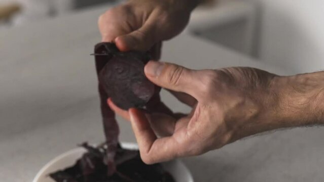 Male cook cleans beetroot for salad