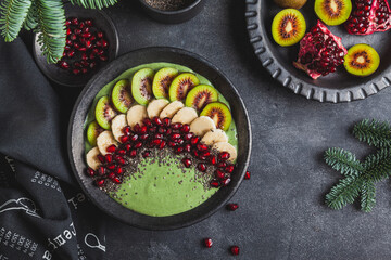 Green smoothie bowl with kiwi, banana and pomegranate.