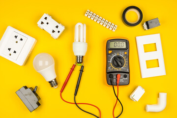Different electrician's supplies on yellow background. Background of professional electrician tools with space for text.electrician concept home electrical repair technician.