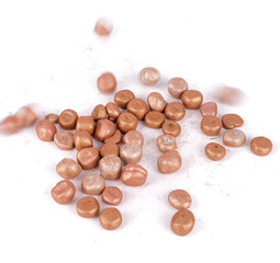 Balls of bronzing face powder falling on table, bronzing pearls isolated on white background