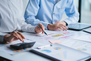 Group of business people meeting together Pointing to the graph assess business profits.