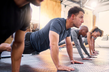 Wellness, team and push ups in gym, workout and fitness for focus, training together and health. Group, diversity or athletic people in sportswear being healthy, strong or with endurance for exercise