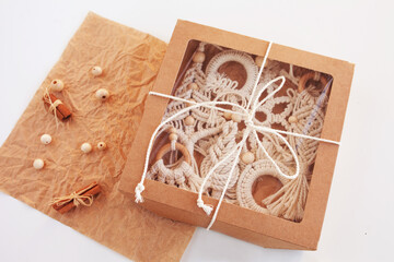 Christmas gift box with macrame decor. Christmas tree, ring, snowflake in style of macramé. Natural materials - cotton thread, wood beads. Eco decorations, ornaments, hand made decor. Copy space
