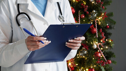 Medical banner concept for Christmas and New Year.A female doctor in white coat,stethoscope,holds...