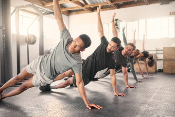 Fitness, exercise and training with a sports group stretching together in gym class for health or...
