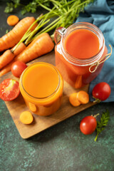 Tomato and carrot juice in a glasses and fresh tomatoes on a stone tabletop. Vitamins drinks juice...