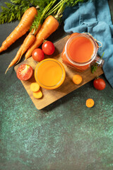 Vitamins drinks juice carrot and tomato, healthy lifestyle. Tomato and carrot juice in a glasses and fresh tomatoes on a stone tabletop. View from above. Copy space.