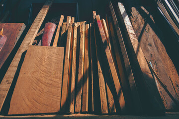 Light and shadow on surface of many old various remaining wooden material used leaning against the...