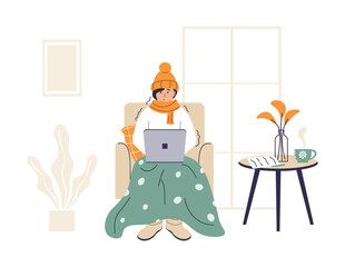 Young woman wrapped in plaid is working on laptop. Low temperature at home. Person freezes from cold warming up with hot drink. Girl sitting in chair in warm clothes. Frozen and shivering character.