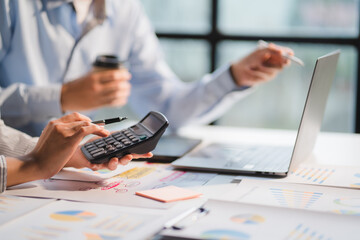 Group of business people meeting together Pointing to the graph assess business profits.