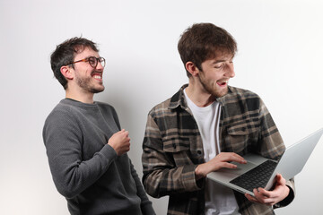 deux collègues et amis regardent un ordinateur portable en souriant