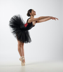Beautiful ballerina dancing with black tutu and black and red body. She danced on ballet pointe shoes. 