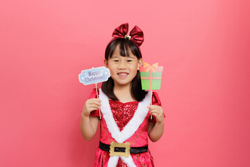Merry Christmas! Young girl celebrating Christmas against pink background