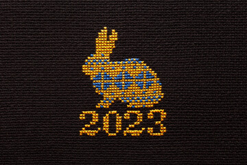 The symbol of 2023 is a rabbit embroidered in the colors of the flag of Ukraine on black fabric.