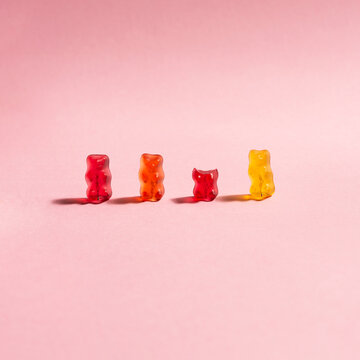 colorful gummy bears on pink background