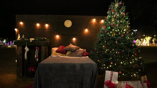 Christmas bedroom with tree, lights, and stockings outdoor at night
