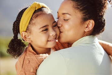 Love, family and mother and girl kiss in a park, happy and relax while bonding and embracing in...