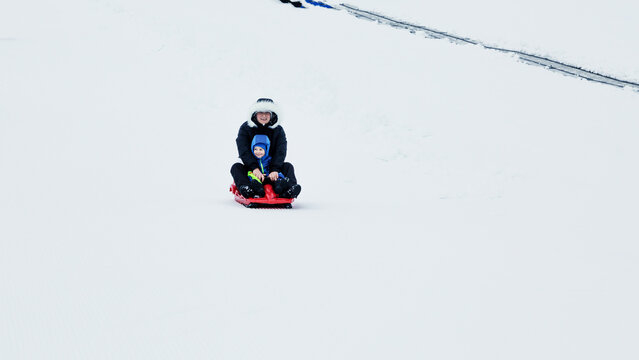 Children sled in the Alps mountains in winter.