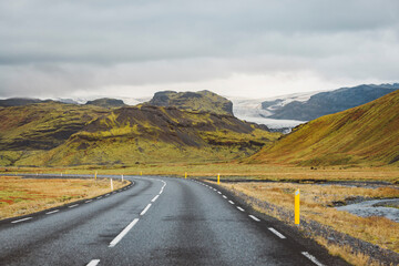 Empty road in Iceland through volcanic landscape to the glacier