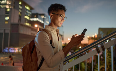 Man, city night and phone text of a student on social media app, internet or web search. Black man...