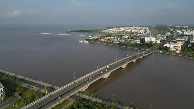 Aerial drone footage over Rach Gia and the meeting with the Mekong river and the sea in south Vietnam. Camera is moving foward along a bridge.