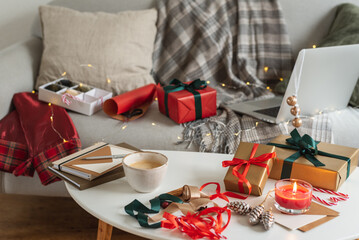 Packing Christmas gifts. View of the apartment in a mess of preparing for Christmas.