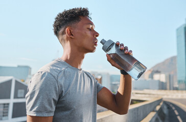 City, fitness and man drinking water after running in street, thirsty after workout in summer heat. Sun, exercise run and sweat, urban black man with healthy lifestyle and water bottle relax on road - Powered by Adobe