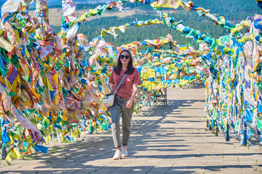 A girl walks under an arch with traditional Buddhist prayer flags in the Rinpoche Bagsha datsan in Ulan-Ude city of the Republic of Buryatia, Russia.