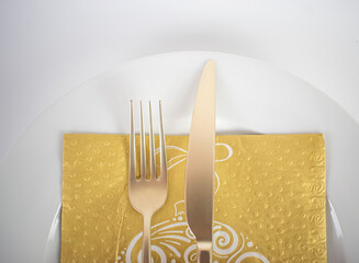Gold cutlery on a plate close up
