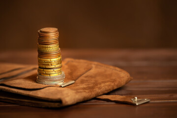 Gold money coins stacks on a wallet on brown background. Business success, solution or financial...