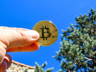 Bitcoin dorée, crypto monnaie tenu à la main
