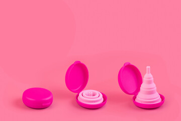 Silicone pink menstrual cups, case. Women's health and alternative hygiene on a pink background flat lay. eco-friendly, Alternative reusable product for female hygiene. Minimalism monochrome.