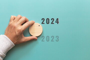 Man hand choose number 2024 on blue background. countdown to 2024. Start concept