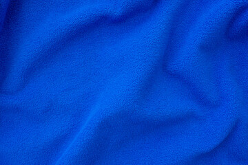 Bright blue fleece cloth. Crumpled, folded blue cloth as background or backdrop, top view