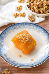 Turkish pumpkin dessert on wood floor. Traditional Turkish cuisine delicacies. Local name kabak tatlisi. close up