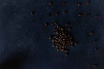 Coffee beans on a dark background, top view of roasted coffee beans, or seeds