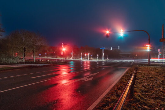 Traffic lights on a traffic junction in a rainy night