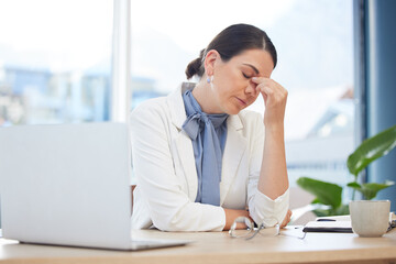 Stress, burnout and healthcare with a doctor woman suffering from a headache while working on a...