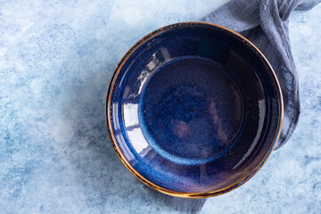 Empty craft blue marble plate and kitchen towel, blue concrete background. Food display menu...