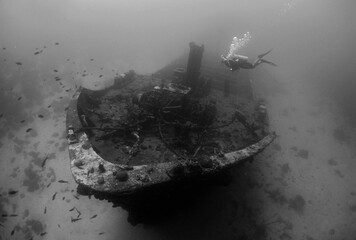 beautiful shipwreck and a diver in the crystal clear waters of the island of Curacao in the...