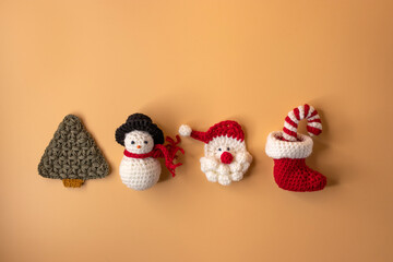 Handmade crochet stocking ,christmas tree, Candy canes, santa claus and gift on orange pastel background. Merry Christmas and happy new year concept..