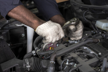 Close up mechanic hands wearing gloves using wrench fixing car in repair service, Car Mechanic...