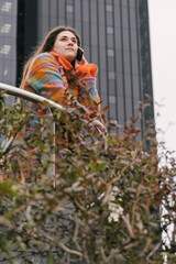 Executive working with a mobile phone in the street with office buildings in the background. Looking up. vertical. High quality photo